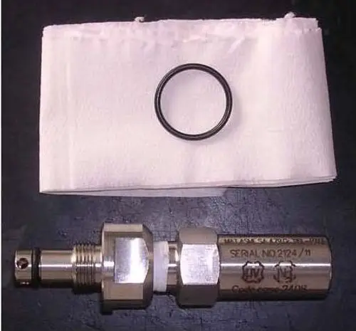 Edelstahl-Sicherheitsventil mit O-Ring und Papierunterlage. Auf dem Ventil sind Seriennummer und die Marke Remeha zu erkennen.